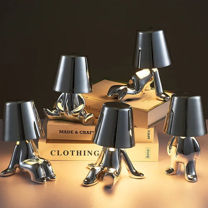 Designerska lampa stołowa LED — figurka w pozycji siedzącej, połyskujące wykończenie | Norivo Norivo