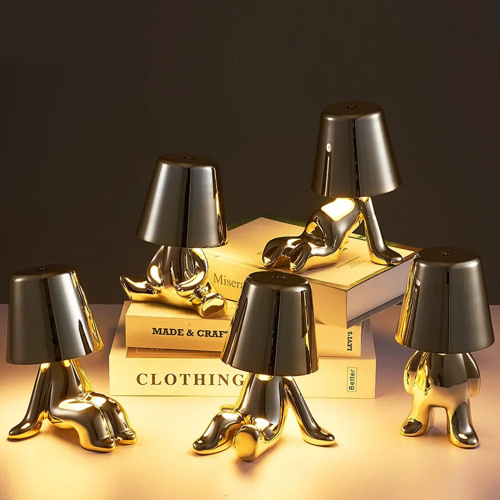 Designerska lampa stołowa LED — figurka w pozycji siedzącej, połyskujące wykończenie | Norivo Norivo