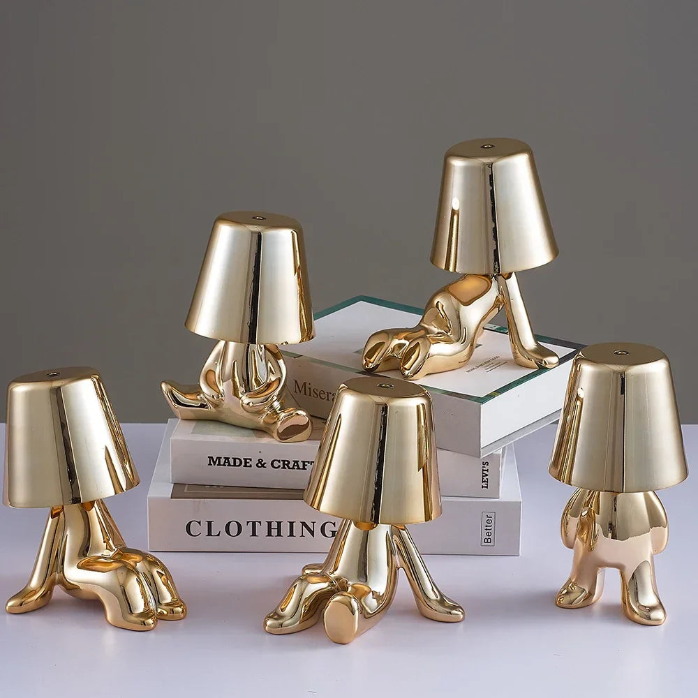 Designerska lampa stołowa LED — figurka w pozycji siedzącej, połyskujące wykończenie | Norivo Norivo