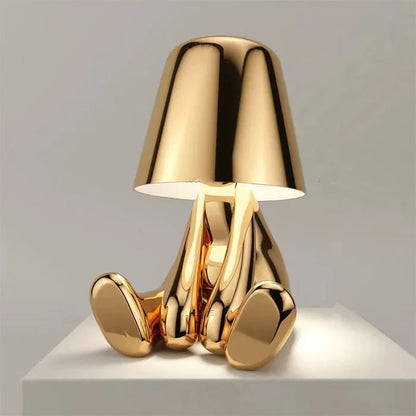 Designerska lampa stołowa LED — figurka w pozycji siedzącej, połyskujące wykończenie | Norivo Norivo